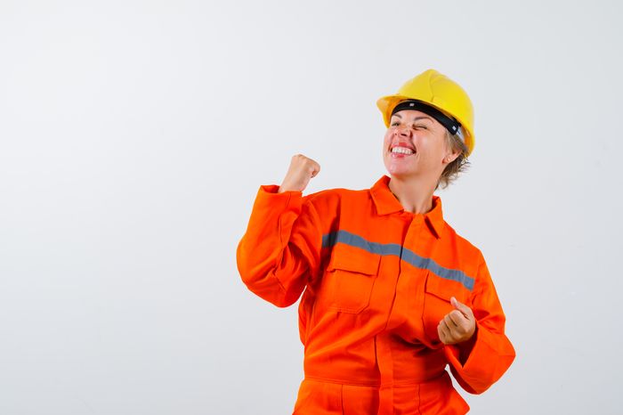Trabalhadora comemorando com uniforme de EPI